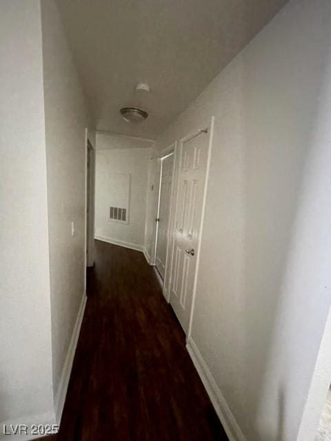 corridor with wood finished floors, visible vents, and baseboards