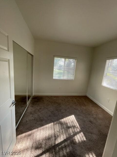 unfurnished bedroom with a closet, carpet, and baseboards