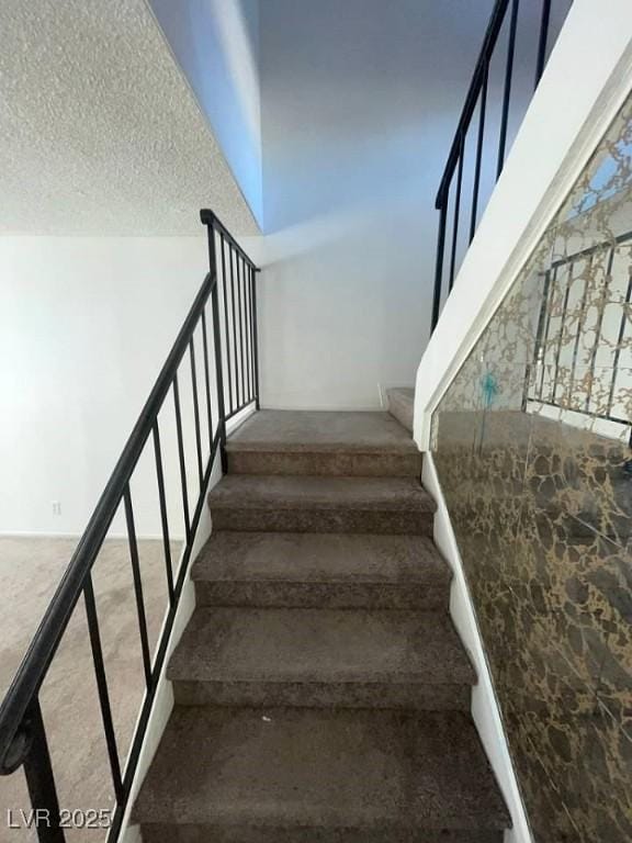 stairs featuring a textured ceiling