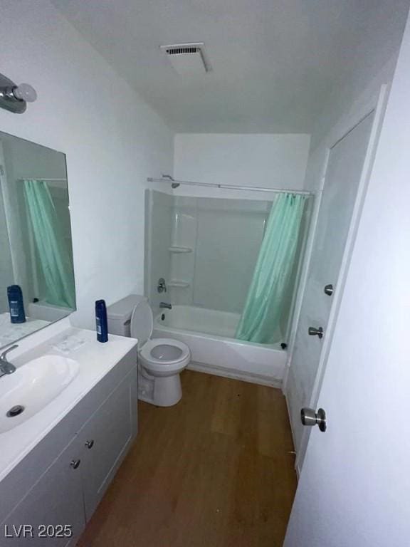 bathroom with shower / bath combination with curtain, visible vents, toilet, vanity, and wood finished floors