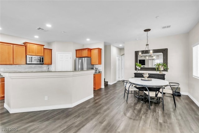 dining room with dark wood-style floors, recessed lighting, visible vents, and a notable chandelier