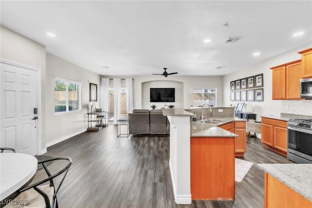 kitchen featuring visible vents, dark wood finished floors, appliances with stainless steel finishes, open floor plan, and a sink