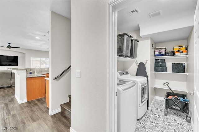 laundry area featuring laundry area, visible vents, a ceiling fan, washing machine and dryer, and a sink