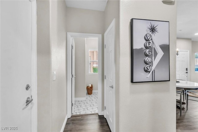 corridor with baseboards and wood finished floors