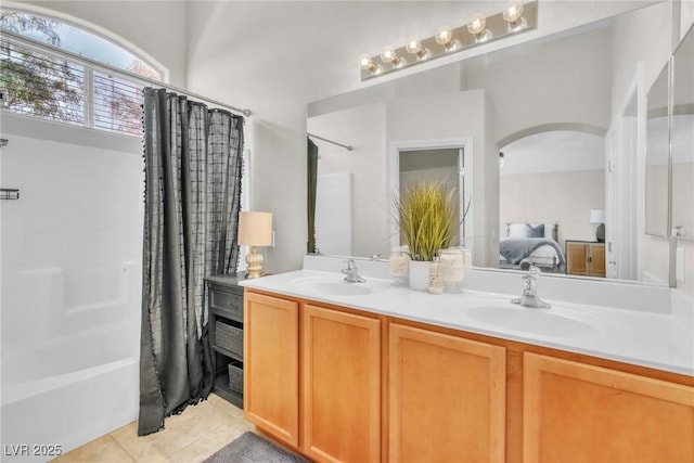 full bath with double vanity, shower / bath combination with curtain, tile patterned flooring, and a sink