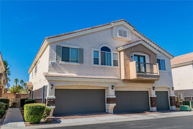 view of front facade featuring a garage, a balcony, central AC unit, and stucco siding