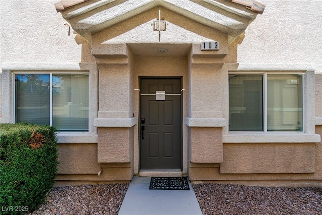 view of exterior entry with stucco siding