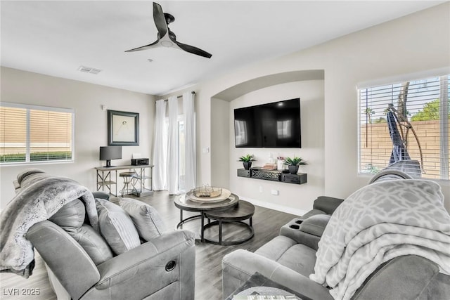 living room featuring a wealth of natural light, wood finished floors, visible vents, and baseboards