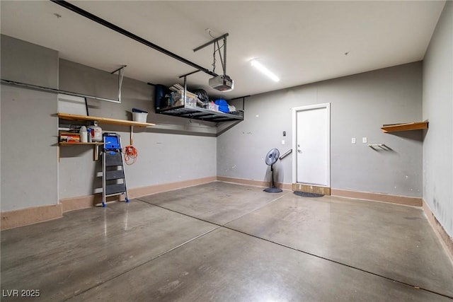 garage with a garage door opener and baseboards