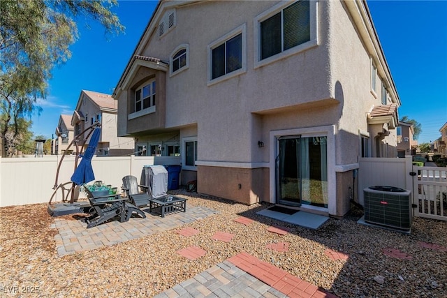 back of house featuring a fenced backyard, a patio, central AC unit, and stucco siding