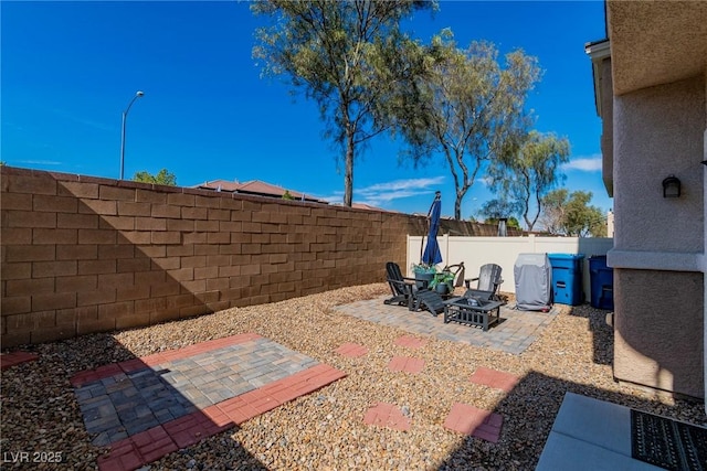 view of patio featuring an outdoor fire pit and a fenced backyard