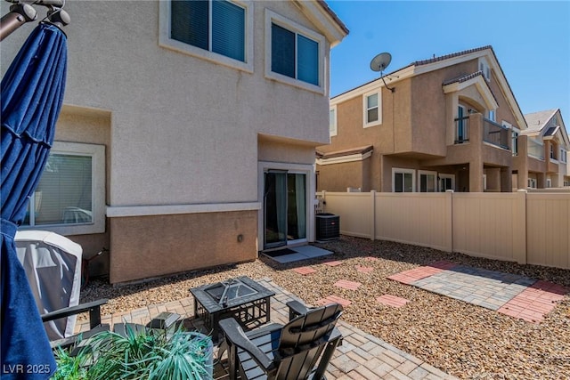 rear view of property with a patio area, fence, and stucco siding