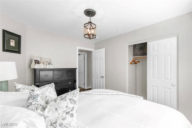 bedroom featuring an inviting chandelier and a closet