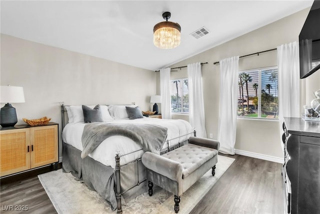 bedroom featuring lofted ceiling, dark wood-style flooring, visible vents, and baseboards