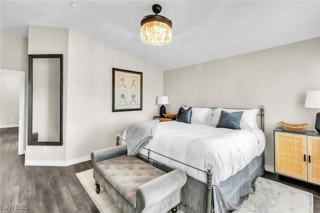 bedroom with vaulted ceiling, dark wood-style flooring, a notable chandelier, and baseboards