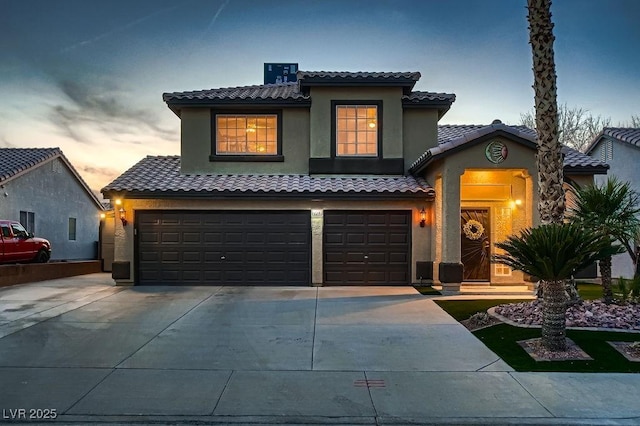 mediterranean / spanish-style house with a garage, a tile roof, driveway, and stucco siding