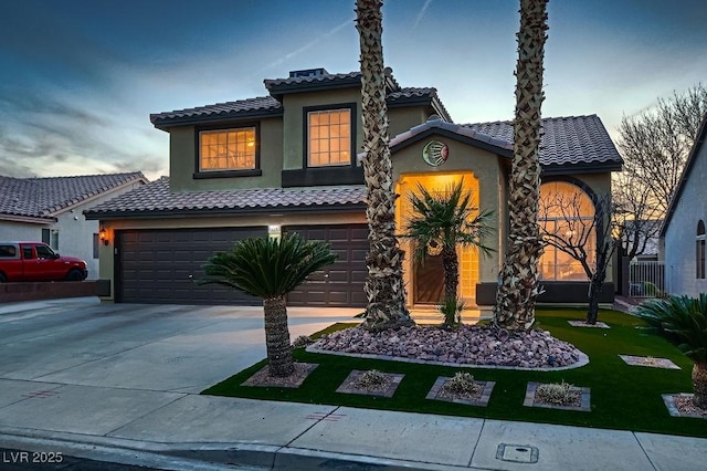 view of front facade with a tile roof, concrete driveway, a front yard, stucco siding, and an attached garage