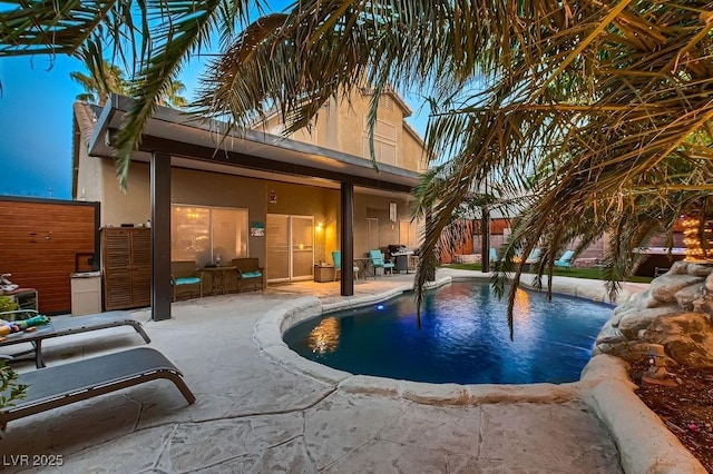 view of swimming pool with grilling area, a fenced in pool, and a patio area