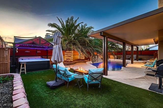 view of patio / terrace featuring a fenced in pool, a fire pit, a fenced backyard, and a hot tub