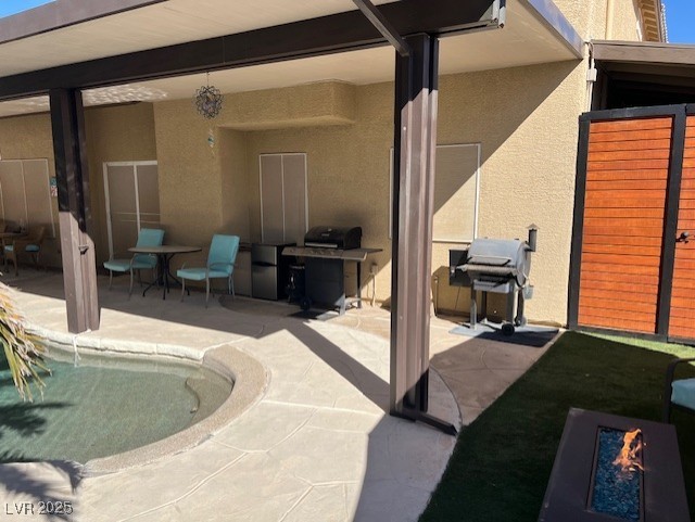 view of patio with a grill and fence