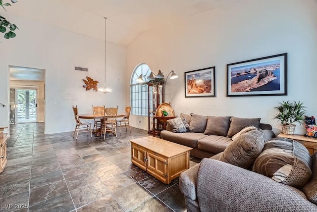 living room with visible vents, high vaulted ceiling, and a notable chandelier