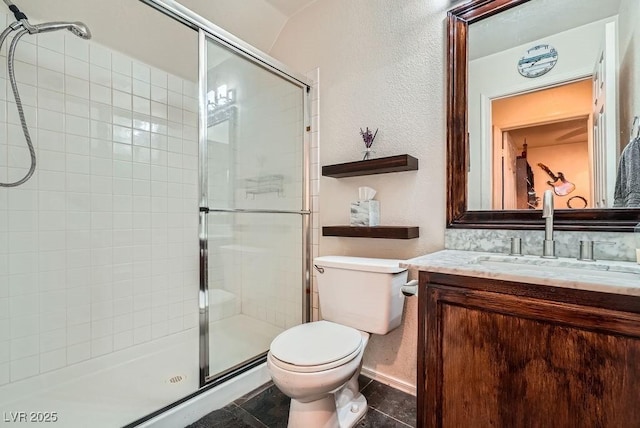 full bathroom featuring tile patterned floors, toilet, a shower stall, vanity, and a textured wall