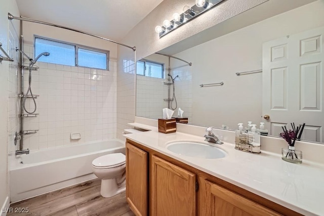 bathroom featuring shower / bathing tub combination, toilet, wood finished floors, and vanity