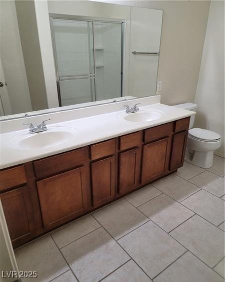 full bath featuring double vanity, a stall shower, tile patterned flooring, and a sink