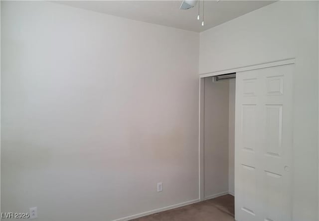 unfurnished bedroom with carpet floors, a closet, and baseboards