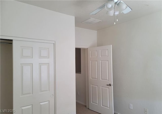 unfurnished bedroom with a closet, light carpet, ceiling fan, and visible vents