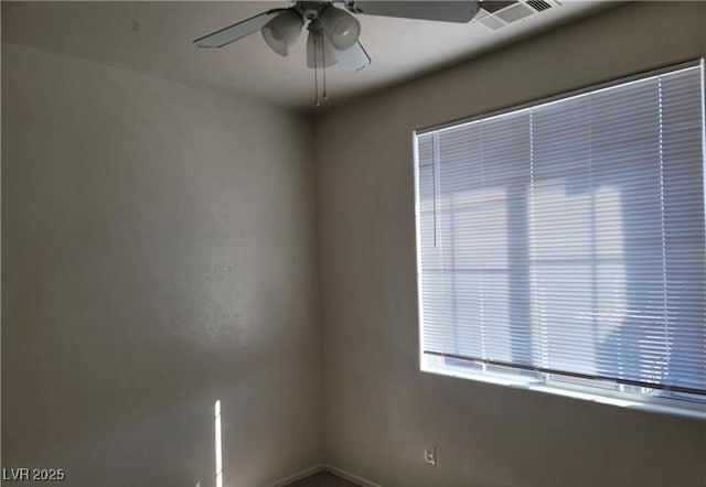 spare room featuring visible vents, ceiling fan, and baseboards