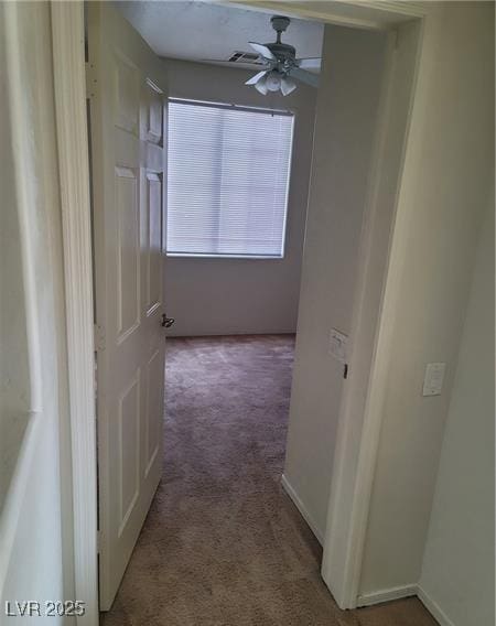 hallway with carpet floors and baseboards