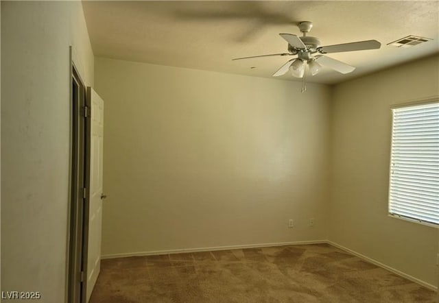 unfurnished room with carpet, visible vents, ceiling fan, and baseboards