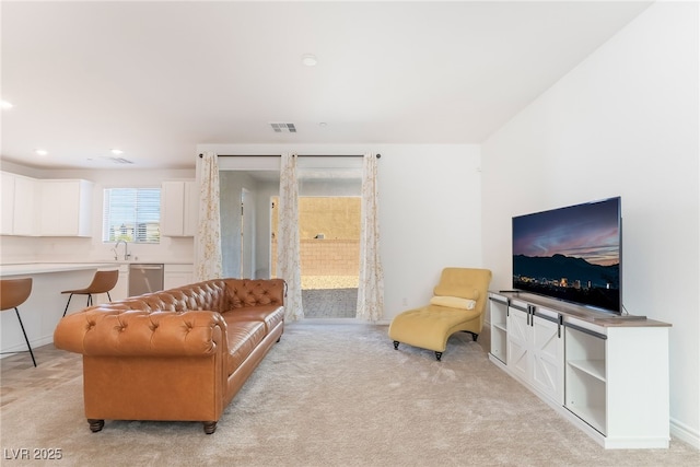 living area with light colored carpet, visible vents, and recessed lighting