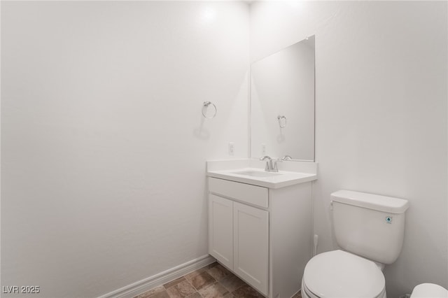 bathroom with vanity, toilet, and baseboards