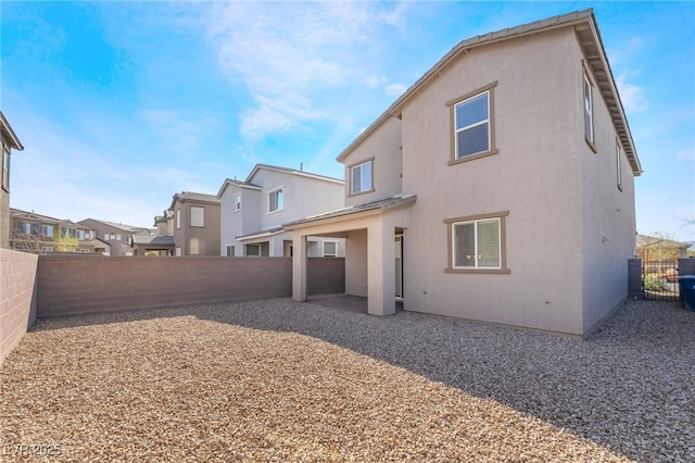 back of house featuring a patio area, a fenced backyard, and stucco siding