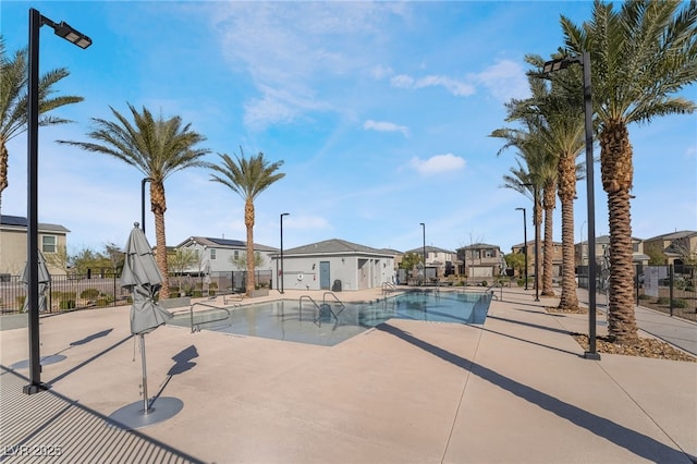 pool with a residential view, a patio, and fence