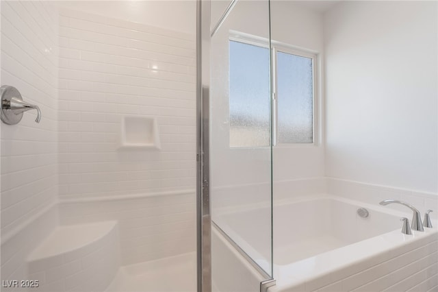 bathroom featuring a stall shower and a garden tub