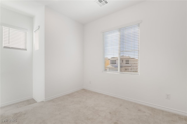 spare room featuring carpet, visible vents, and baseboards