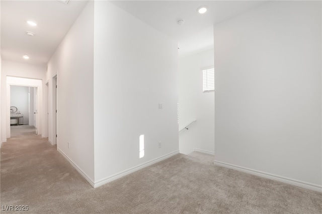 hall featuring recessed lighting, light carpet, and baseboards