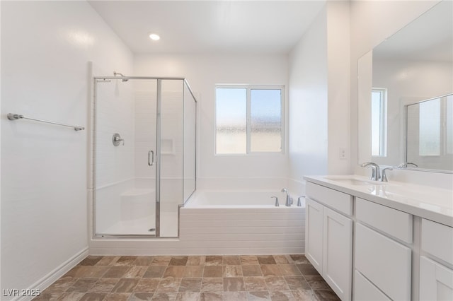 bathroom with a stall shower, a garden tub, and vanity