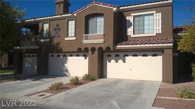 view of front facade with a garage, a tile roof, driveway, and stucco siding