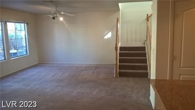 unfurnished room featuring a ceiling fan, stairway, and carpet flooring