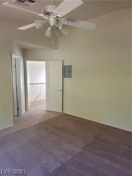 spare room featuring electric panel, carpet flooring, ceiling fan, and visible vents