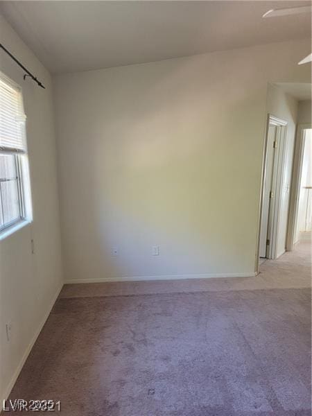 unfurnished room with light carpet and baseboards