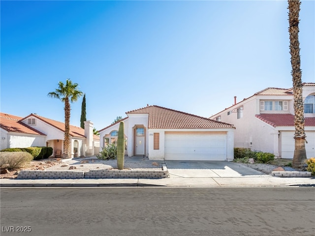 mediterranean / spanish-style house with driveway, an attached garage, a tile roof, and stucco siding