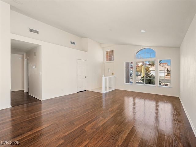 unfurnished living room with high vaulted ceiling, wood finished floors, and visible vents