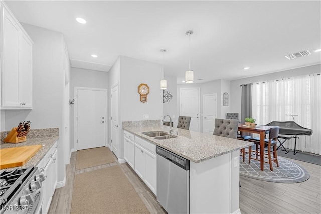 kitchen with white cabinetry, visible vents, stainless steel appliances, and a sink