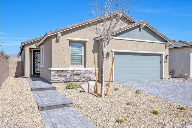 ranch-style house with a garage, stone siding, decorative driveway, and stucco siding