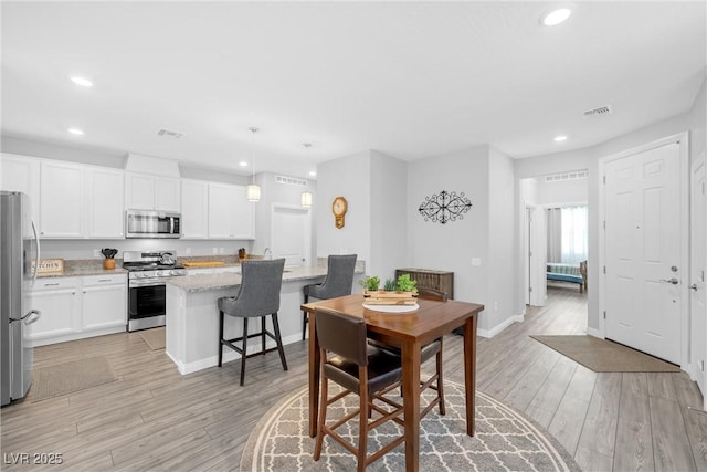 dining space featuring light wood-type flooring, visible vents, baseboards, and recessed lighting